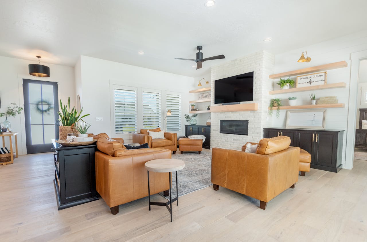 A stylish living room featuring leather couches, a TV, and contemporary design elements.